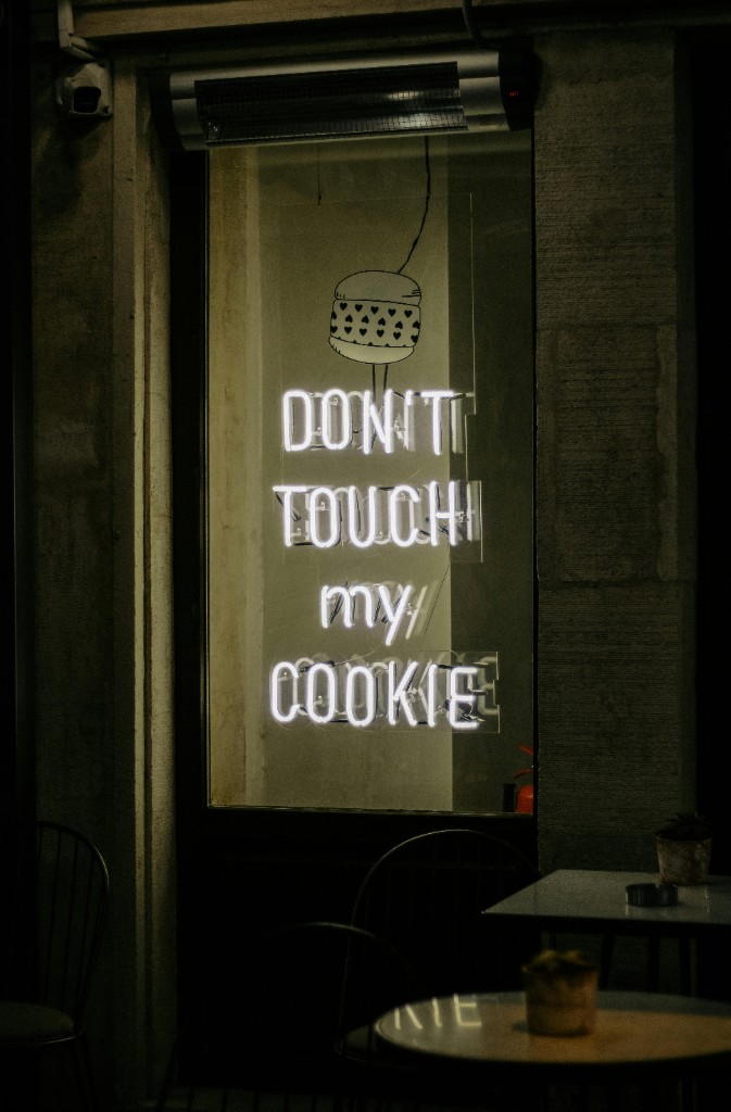 Neon sign in a shop window at night: Don’t Touch my Cookie, with a cookie graphic.